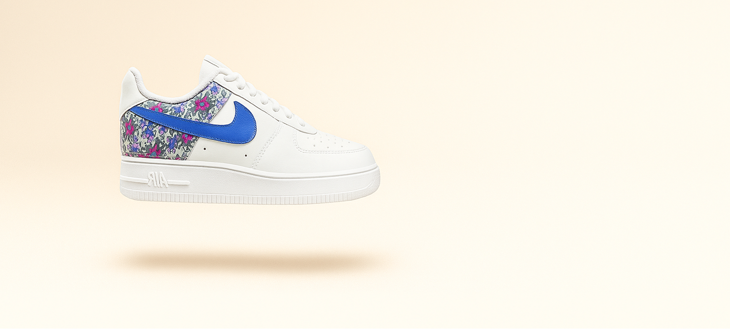 White sneaker with a blue Nike logo and floral pattern on a beige background